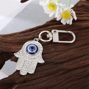 Macro detail of Hamsa Hand keychain with blue evil eye and sparkling rhinestones