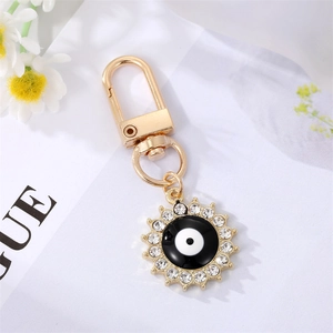 Bohemian gold sun keychain with evil eye enamel pattern and white crystals on Vogue card