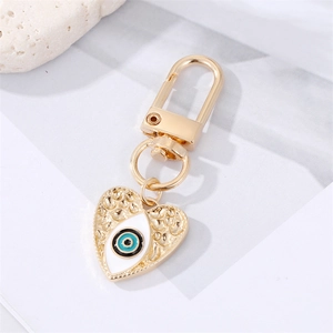 Golden heart evil eye keychain with blue enamel detail and embossed textures