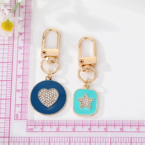 Detail of colorful enamel heart and star keychain pendants with gold plating and rhinestones