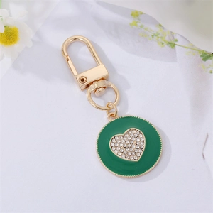 Golden keychain with green enamel round pendant and sparkling rhinestone heart detail