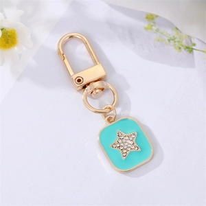 Macro detail of mint green enamel keychain with shimmering rhinestone star charm