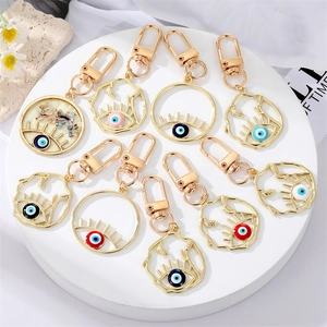 Porte-Clés Pendentif en Alliage Creux Mauvais Œil Géométrique Rond Cils Bleu Nazar Œil Charme de Sac Accessoire Bijou