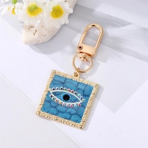 Golden evil eye heart keychain with colorful rhinestones on deep blue background
