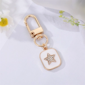 Detailed macro view of gold-plated star pendant with white enamel and sparkling rhinestones
