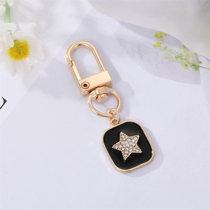 Star charm keychain with black enamel and rhinestones on a gold metal lobster clasp