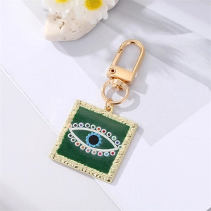 Golden keychain featuring a square dark green evil eye pendant with enamel and crystals
