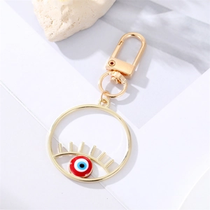 Porte-clés Evil Eye en alliage doré avec émail bleu et fermoir mousqueton sur fond blanc