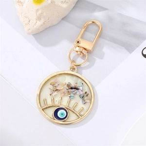 Porte-clés œil grec doré avec incrustation de nacre colorée et pendentif en émail