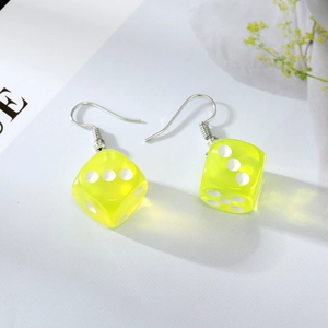Detailed close-up of fluorescent green resin dice earrings on minimalist background