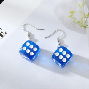 Close-up of blue transparent resin dice earrings with silver hooks and white dots