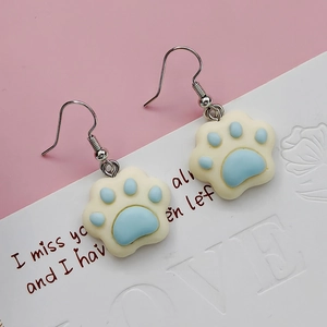 Detailed view of cute resin cat paw drop earrings with blue pads and silver hooks