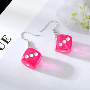 Detailed view of pink translucent resin dice earrings with white dots and silver hooks