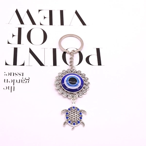 Tribal evil eye keychain featuring silver turtle pendant with blue resin and rhinestones