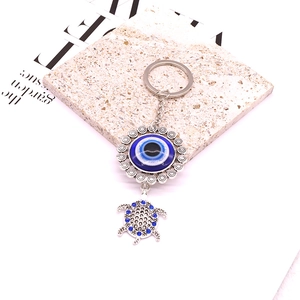 Detailed close-up of tribal silver turtle keychain with blue nazar evil eye and crystals