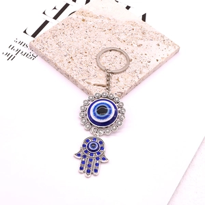 Detailed close-up of vintage silver Hamsa Hand and Evil Eye keychain with blue rhinestones
