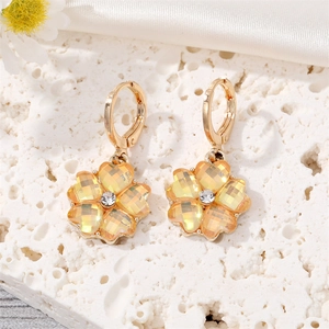 Détails de boucles d'oreilles fleur en cristal jaune sur pierre blanche et soie