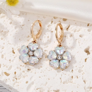 Détail macro de boucles d'oreilles fleur irisées avec anneau doré et cristal brillant