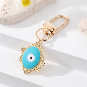 Detalle del llavero de ojo turco con esmalte azul y un borde de metal dorado muy ornamentado