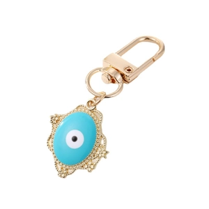 Llavero de ojo turco dorado con gota de esmalte azul y marco floral sobre fondo blanco