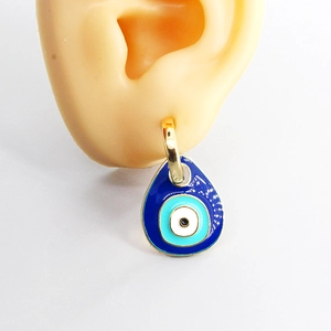 Elegant gold evil eye drop earrings with blue enamel finish shown on an ear model