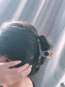 Vue détaillée d'une pince à cheveux en résine transparente avec de vraies fleurs séchées