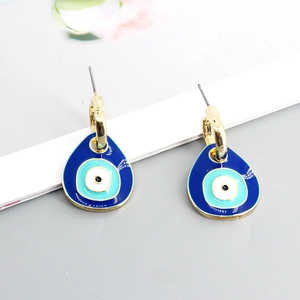 Detailed close-up of blue evil eye drop earrings with polished gold finish and enamel inlay