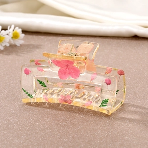 Détail de la pince à cheveux rectangulaire en résine avec de vraies fleurs roses et feuilles