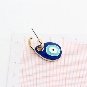 Macro detail of gold evil eye earring showing blue enamel droplet and size measurement