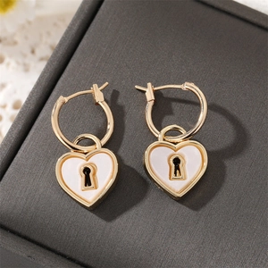 Retro gold heart hoop earrings with white enamel finish and central keyhole detail
