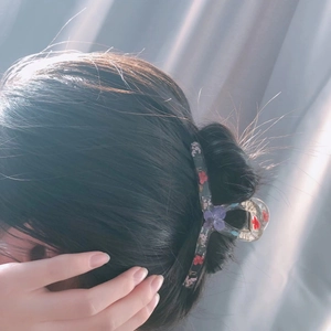 Pince à cheveux élégante en résine avec fleurs séchées colorées portée par un modèle