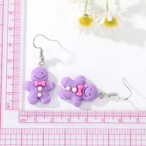 Détail des boucles d'oreilles bonhomme pain d'épice violet avec échelle de taille