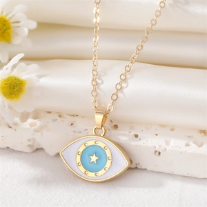 Detail der Goldkette mit blauem Emaille-Auge und Sternanhänger auf Seidenstoff
