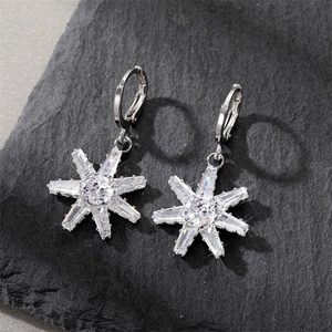 Detailed macro view of silver star earrings with clear cubic zirconia on stone background