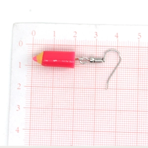 Pink resin pencil dangle earrings with silver fish hooks on a grid background