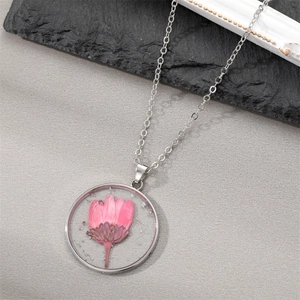 Elegant round silver necklace with pink dried flower specimen and shimmering silver flakes