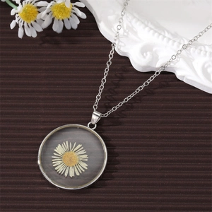 Preserved white daisy pendant necklace with silver chain on an elegant vintage background
