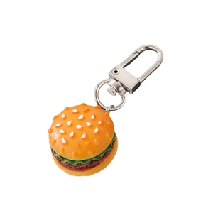 Realistic mini hamburger keychain with green lettuce and brown meat on white background