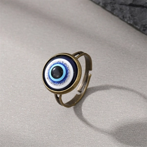 Vintage evil eye ring with blue glitters on dark background with stone accent