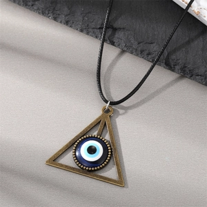 Close-up of vintage bronze triangle evil eye pendant on a black waxed cord necklace