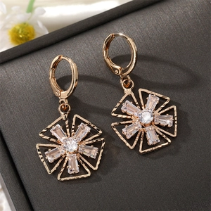 Elegante goldene Blumen-Ohrringe mit Zirkonia auf grauem Schmuckkästchen-Hintergrund