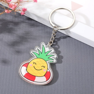 Cute acrylic cartoon pineapple keychain with silver ring on a minimalist background