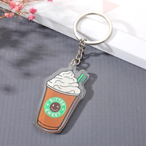 Macro view of a coffee cup acrylic keychain with Bitter Sweet logo on grey texture