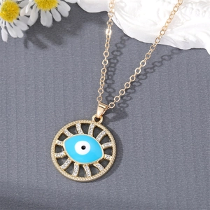 Golden Evil Eye necklace with sparkling rhinestones and blue enamel on a textured background