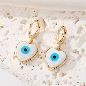 Vintage gold heart earrings with seashell evil eye inlay on stone background