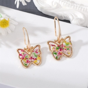 Detail of golden butterfly earrings with real dried flowers embedded in clear resin hooks