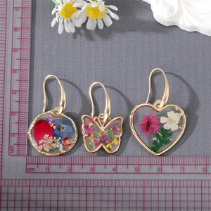 Handmade resin earrings with dried flowers in gold heart and butterfly frames