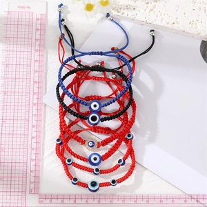 Macro detail of handmade evil eye braided bracelets with blue beads and crystals