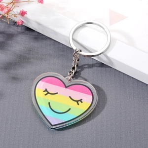 Close-up of heart-shaped rainbow acrylic unicorn keychain with smiling cartoon face