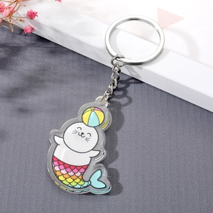 Detail of cute acrylic seal mermaid keychain with colorful scales and silver metal ring